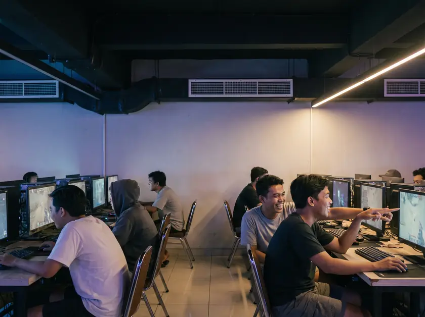 Computer club in Denpasar with exposed ducts and supply grilles above rows of gaming PCs