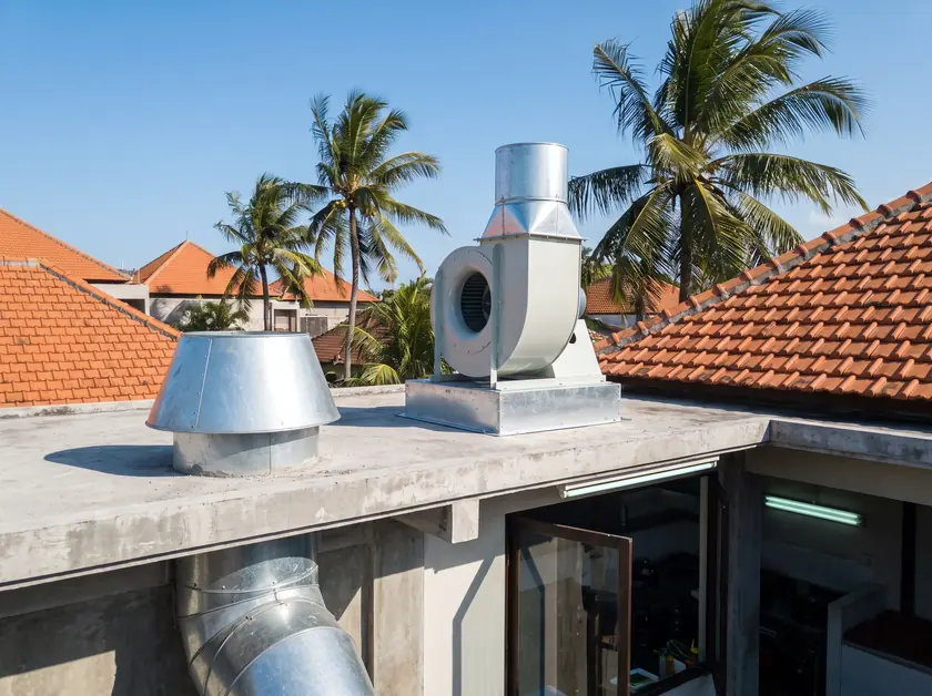 Centrifugal kitchen exhaust fan with a vertical discharge stack on a Seminyak rooftop